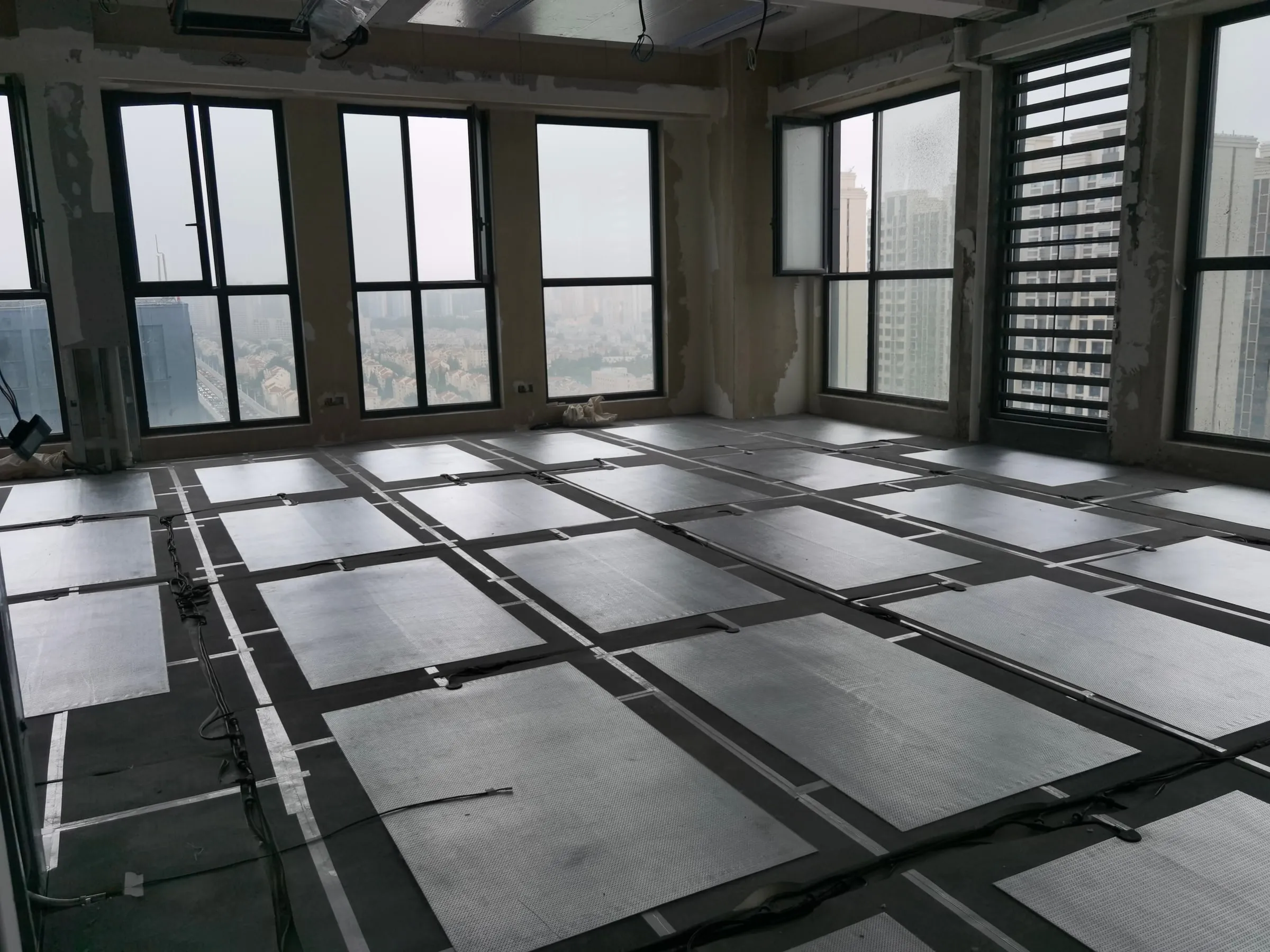 EGS floor heaters laid across an open-plan office with floor-to-ceiling windows