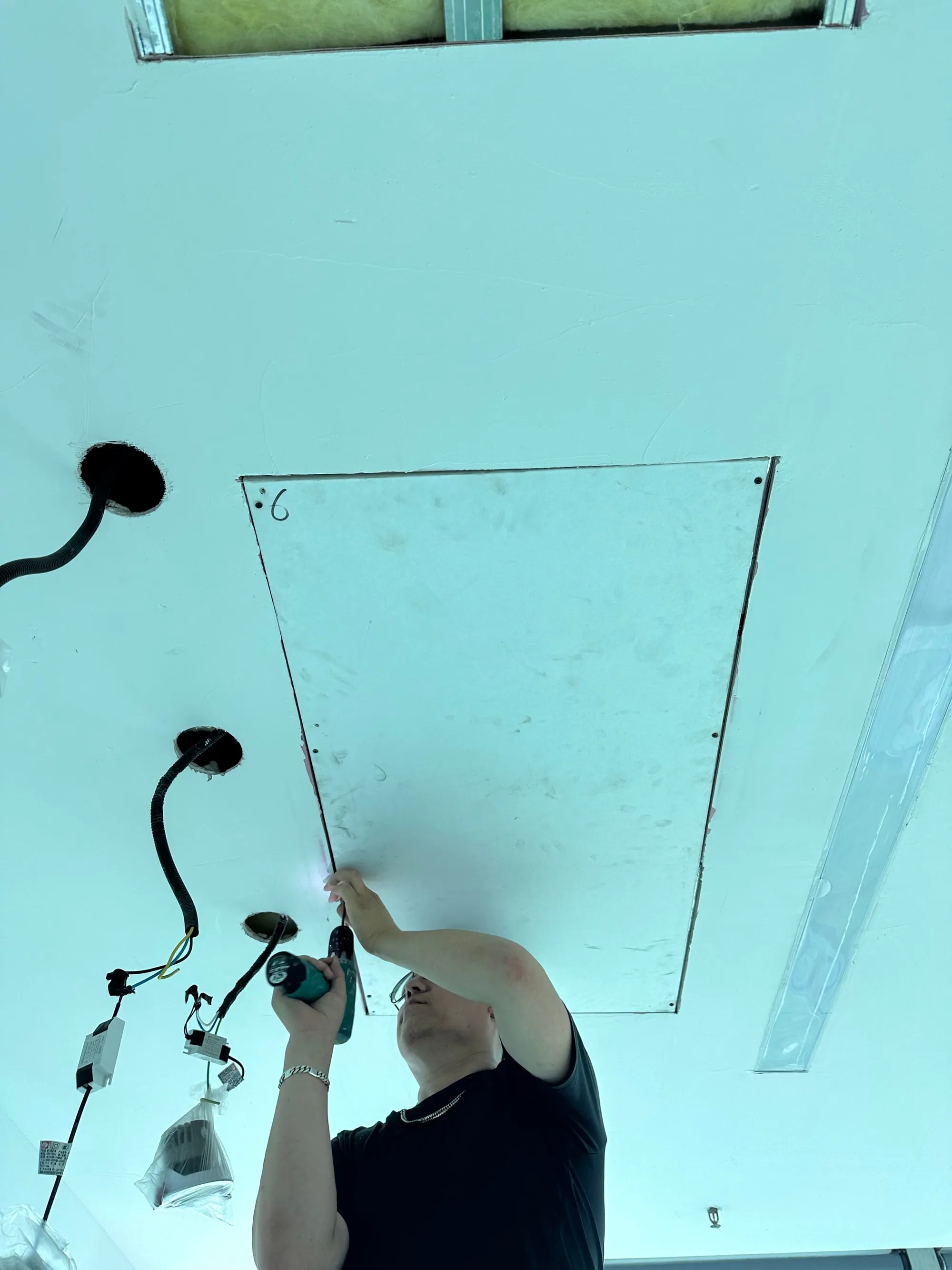 An installer screwing a PowerBoard 250 into the ceiling