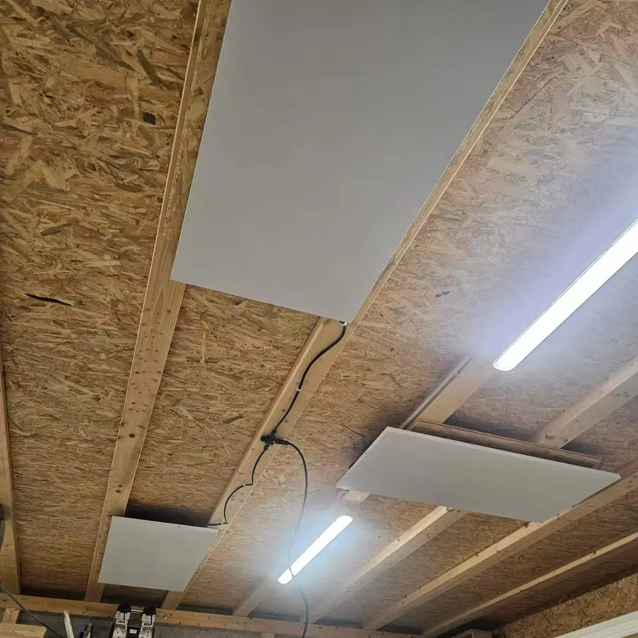 PowerBoard panels mounted between exposed timber joists in a workshop ceiling