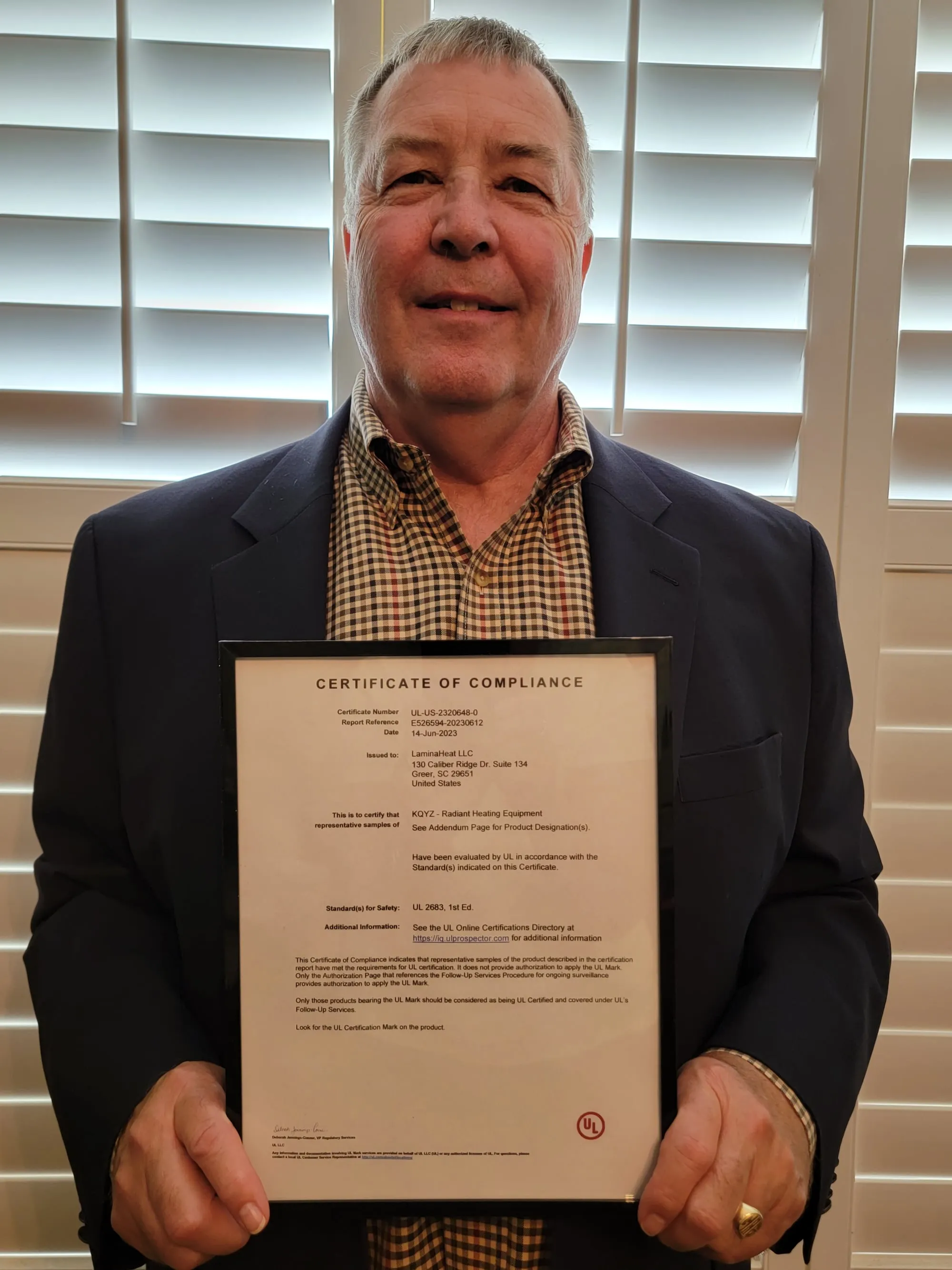 The UL Certificate of Compliance for the carbon-fibre heating film, held up to the camera