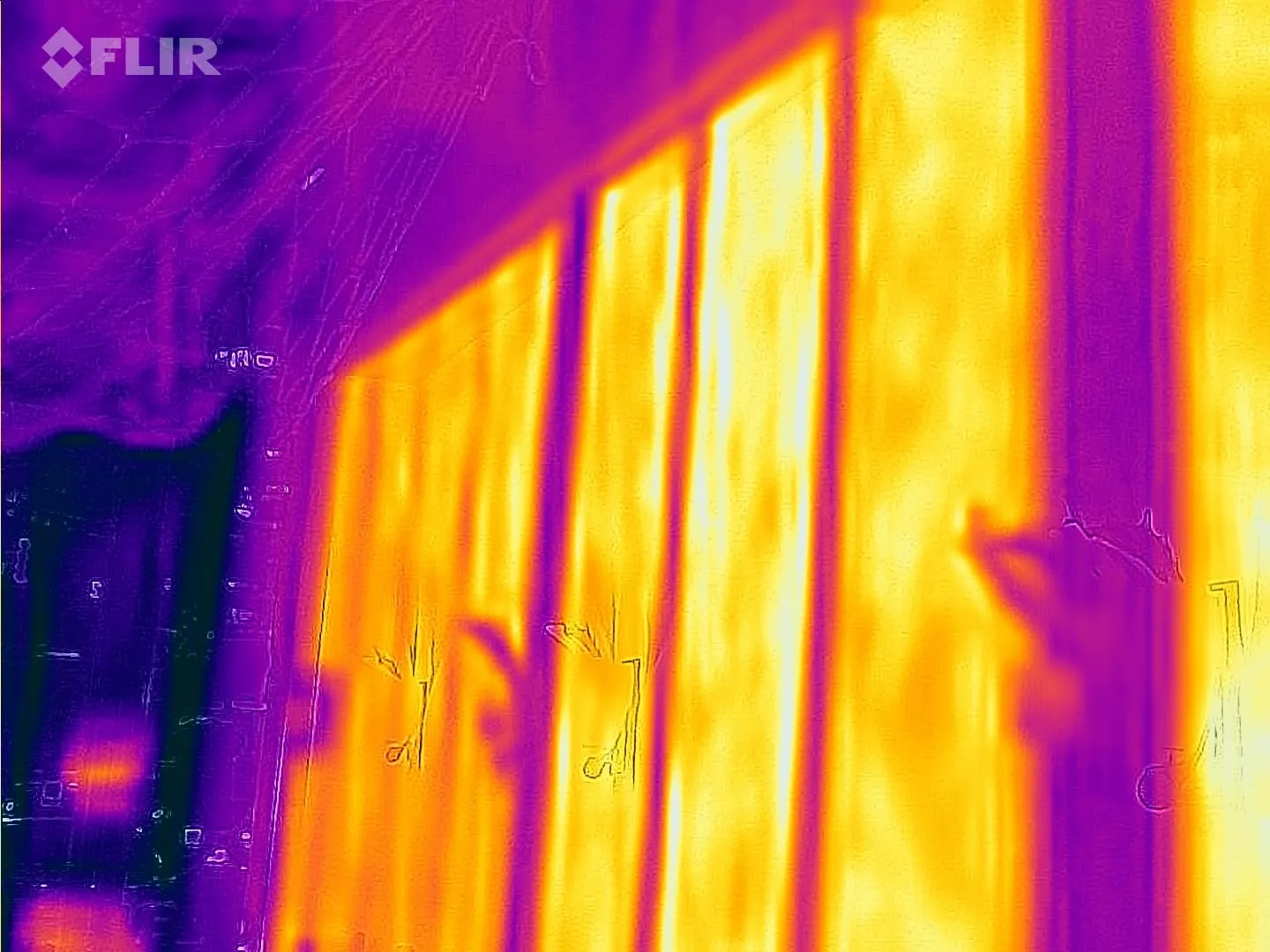 Thermal camera image of heated wall elements warming a room evenly