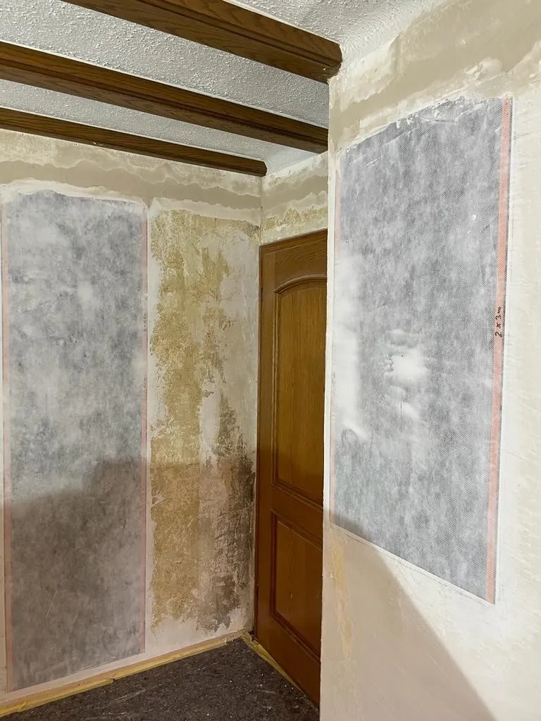 A heritage room with solid walls and tall windows, heated by wall elements